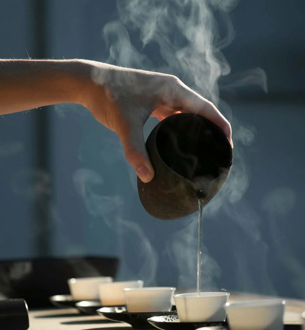 热茶注入茶杯，蒸汽升腾